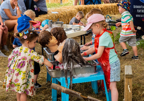 Children washing the hair on styling doll heads