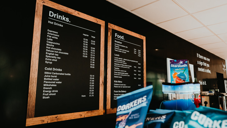 Black menu boards showing a selection of drinks and food options