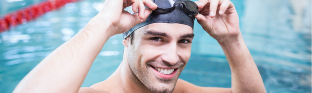 Smiling man in swimming cap with goggles