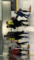 Group of young children learning to ice skate with penguin aids preview