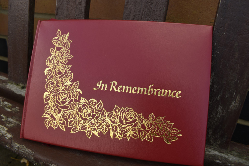 Red leather book with gold decoration and 'In Remembrance' lettering