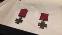 Two Victoria Cross medals lying on white tissue paper.  preview