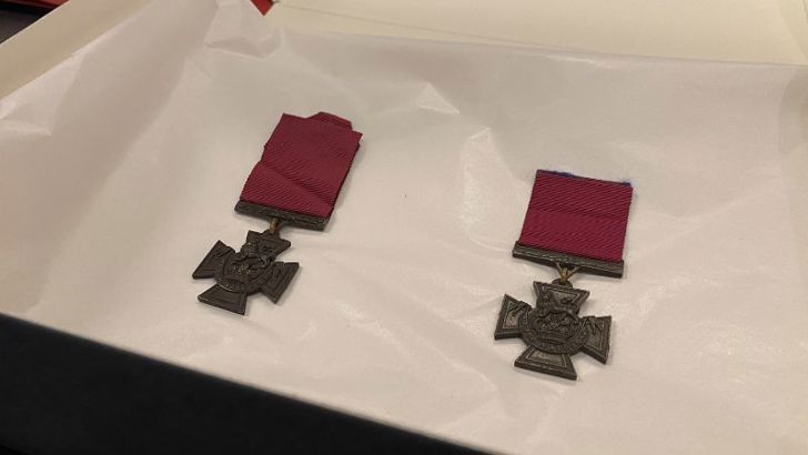 Two Victoria Cross medals lying on white tissue paper. 