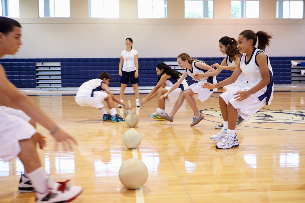 Young people in a sports hall, playing dodgeball