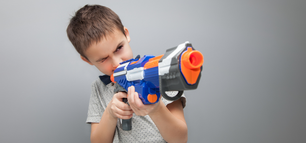 Child holding a toy gun.