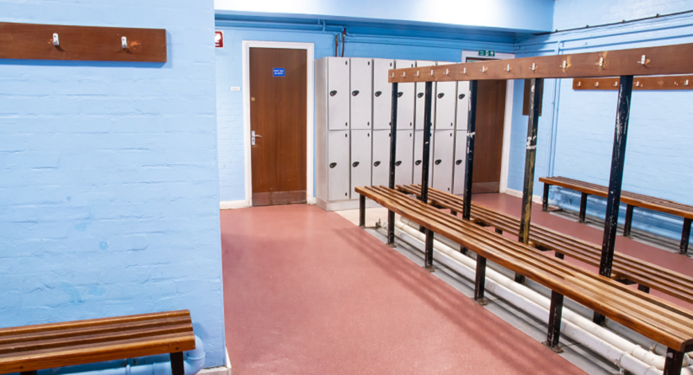 Changing room with benches in the middle and lockers against the wall