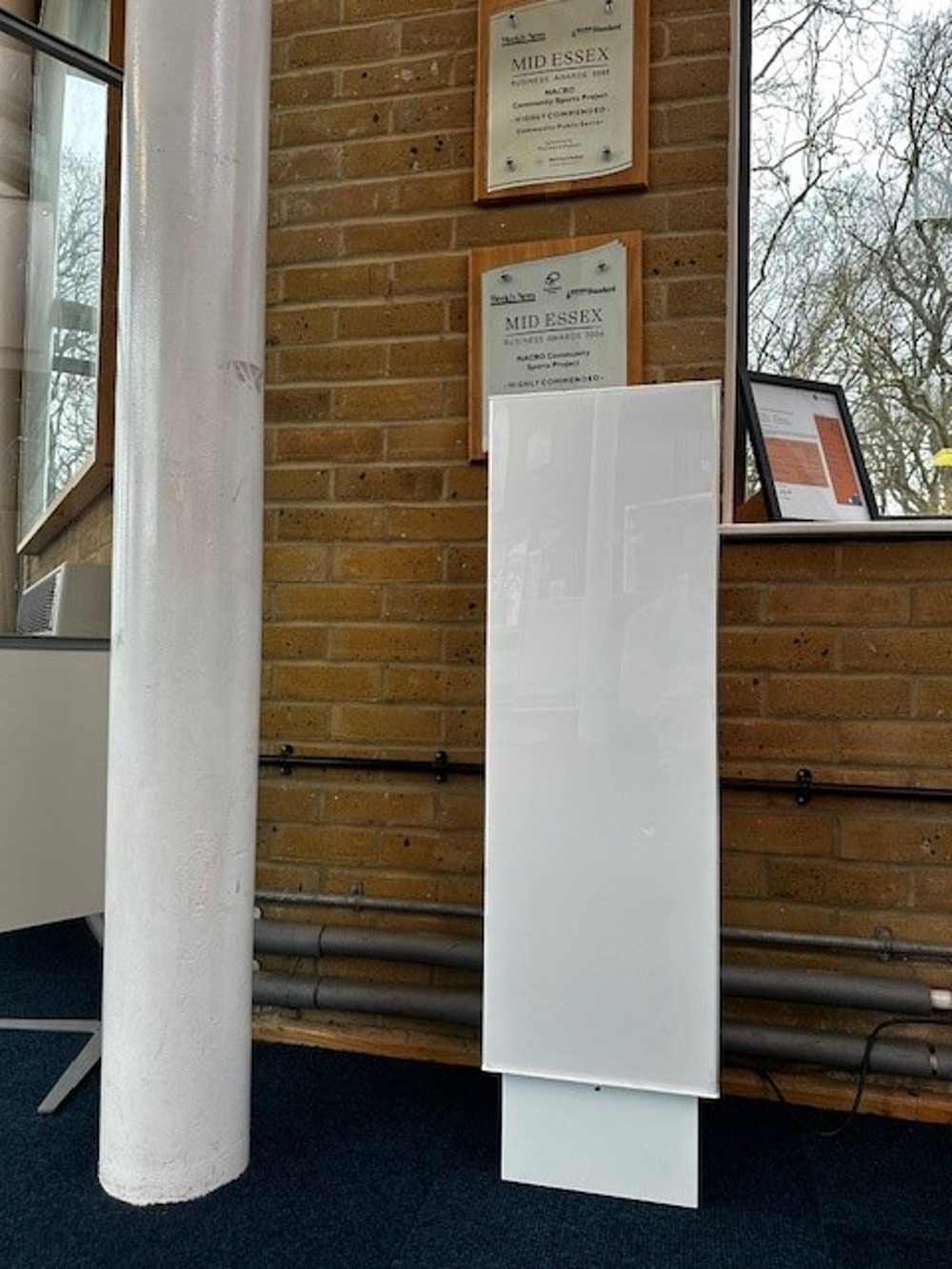 Tall white pod next to white pillar