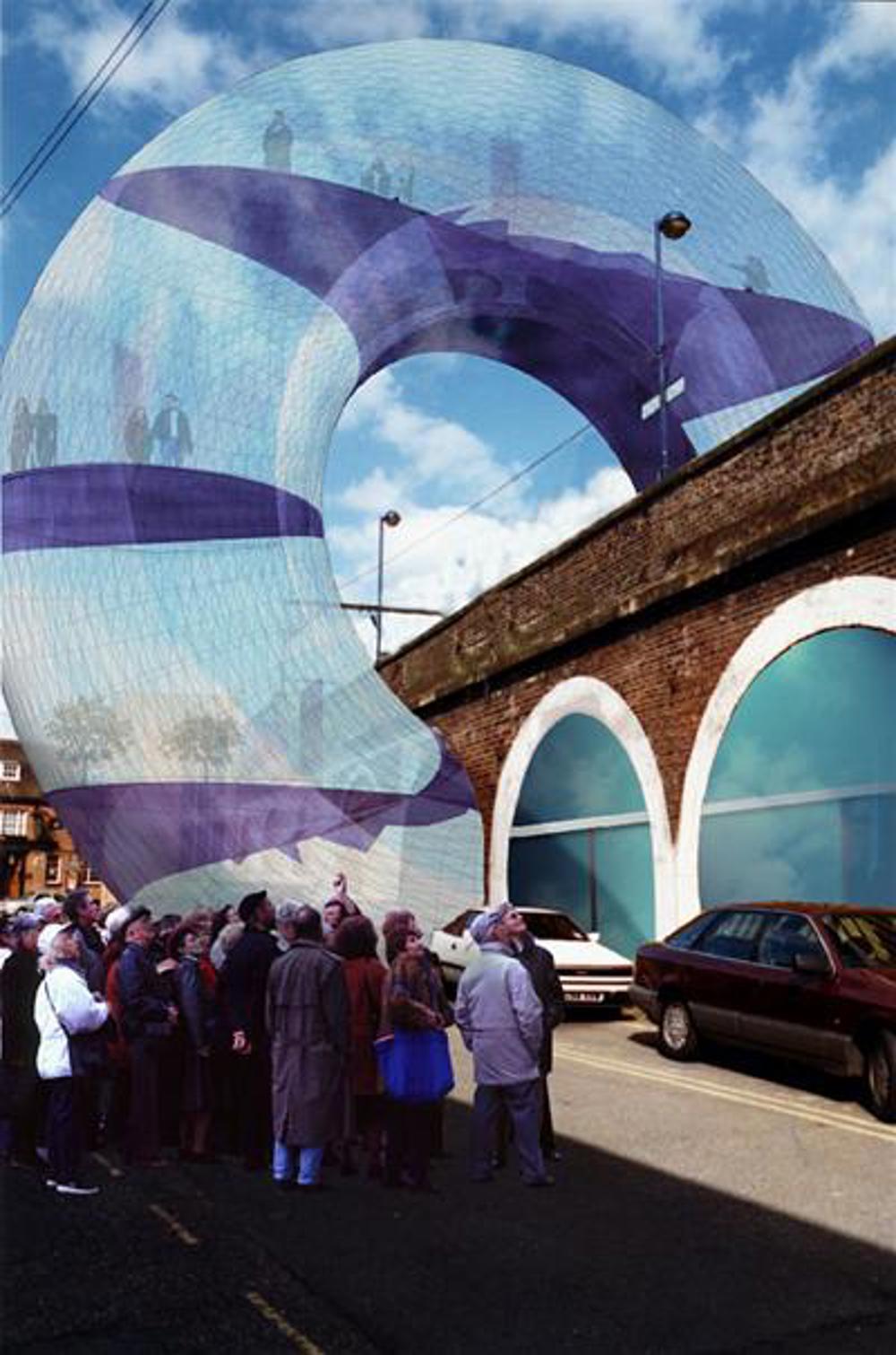 Artist's impression of crowd of people looking a large ring-like structure over a bridge