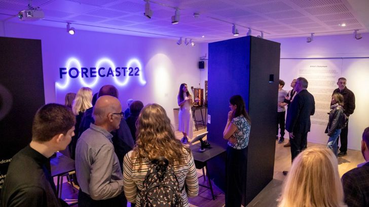 A group of people standing inside the temporary Forecast22 exhibition on its launch night. 