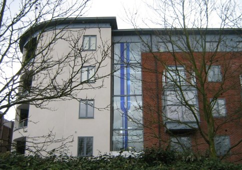 Blue glass panels depicting stylized river in window of block of flats