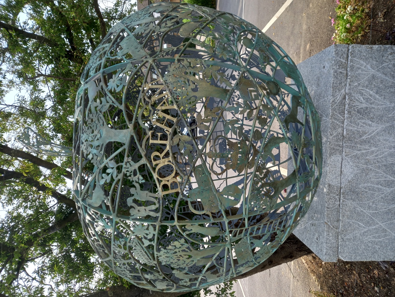 Large art installation in the shape of an apple, made of intricately arranged copper pieces