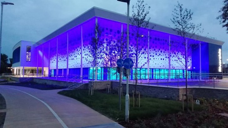 Riverside Leisure Centre lit up blue at dusk